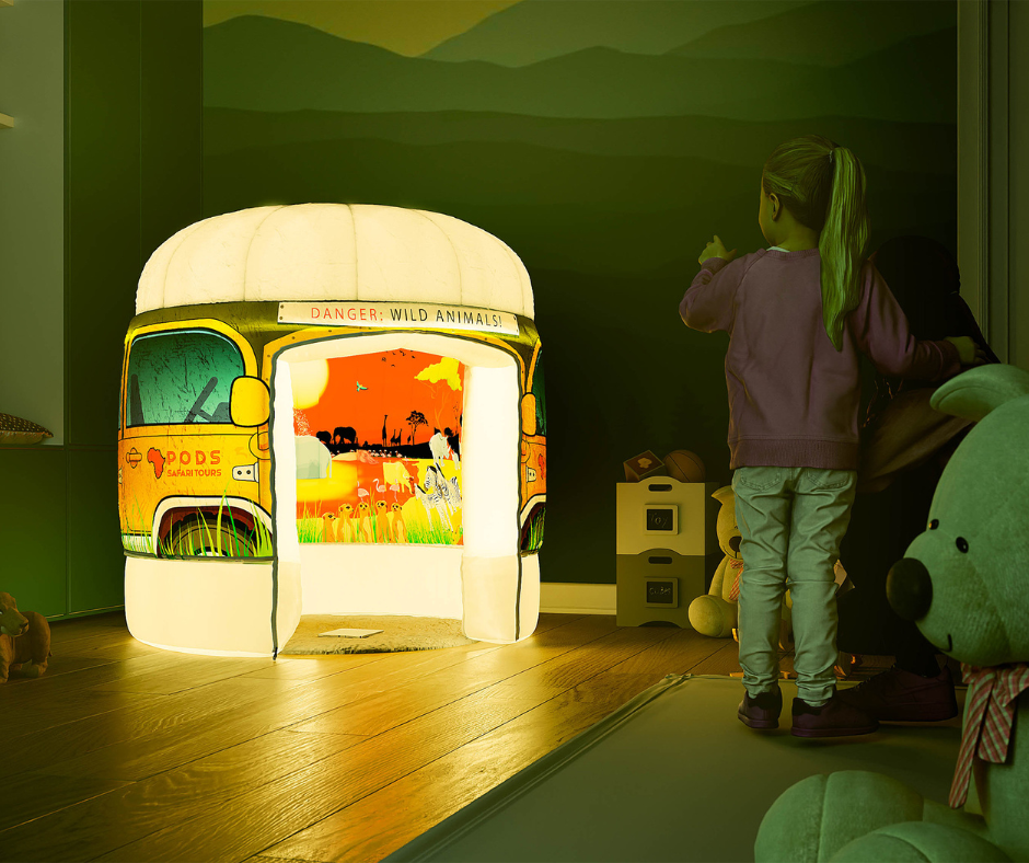 A PODS Play inflatable sensory play tent is illuminated in a child's room, featuring a colourful safari theme.