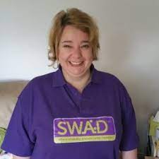 Lorriane, blonde hair and smiling with a purple top on with SWAD logo